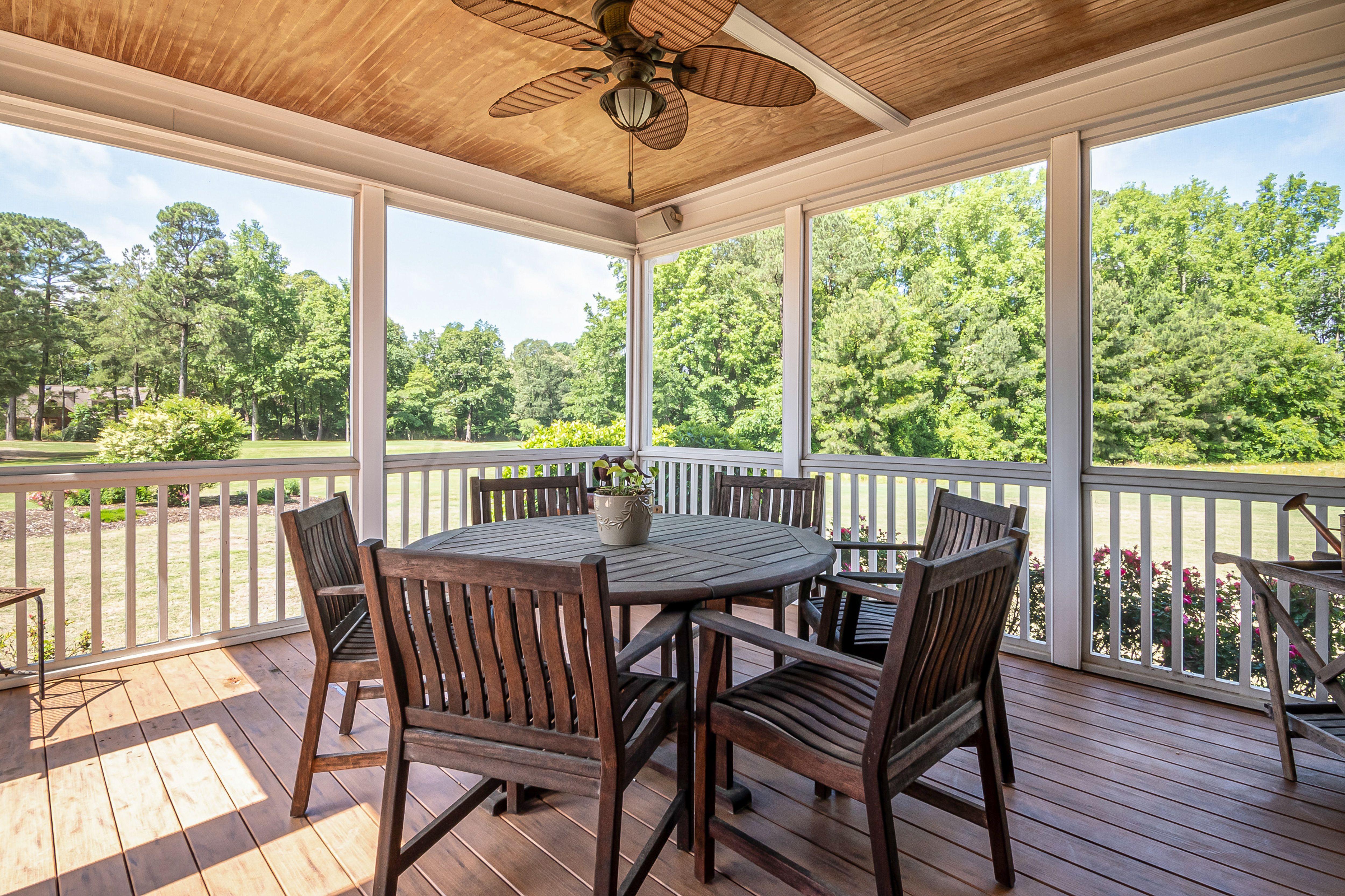 Spacious outdoor patio with wooden furniture and scenic garden view